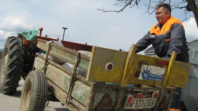 Rade Jovanović kod svog traktora kojim skuplja otpad - © Foto: Biljana Nenković